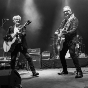 black and white image of two men playing the guitar 